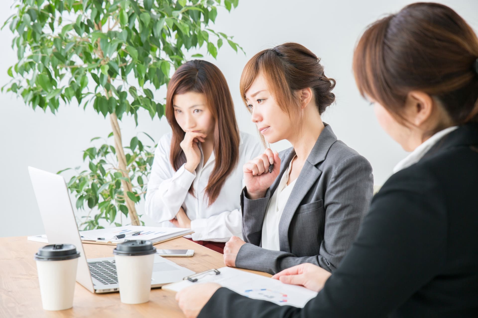 オフィスでデザインに頭を悩ませる複数社員