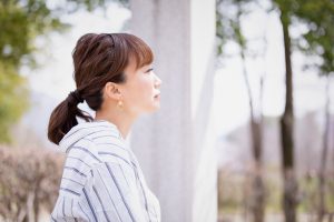 ぼーっと中空を見ているビジネスカジュアルの女性の横顔
