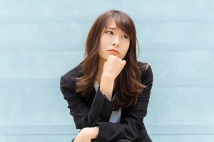顎をついて悩んでいる女性