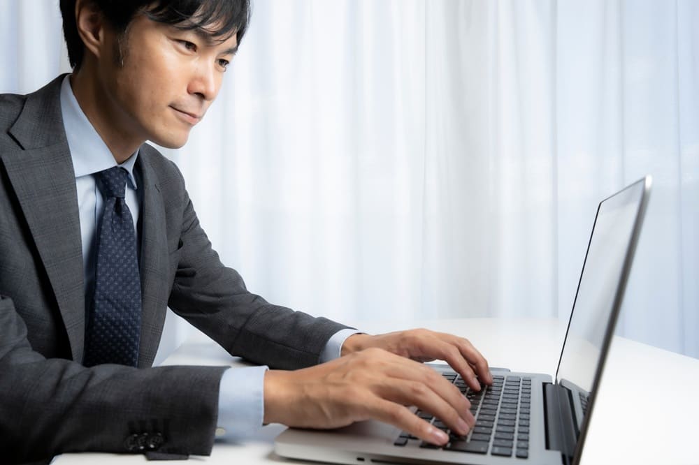 Xの運用代行でPC操作をしている男性プロマーケター