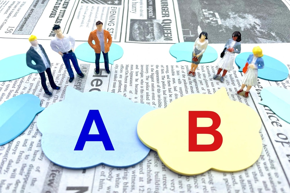 吹き出しに描かれた「A」と「B」どっちを選べばいいのか迷っている複数の小型人形