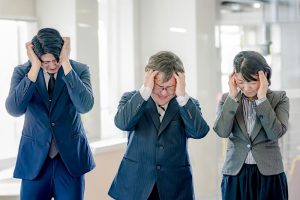 人材が見つからず頭を抱えているスーツを着た男女3人