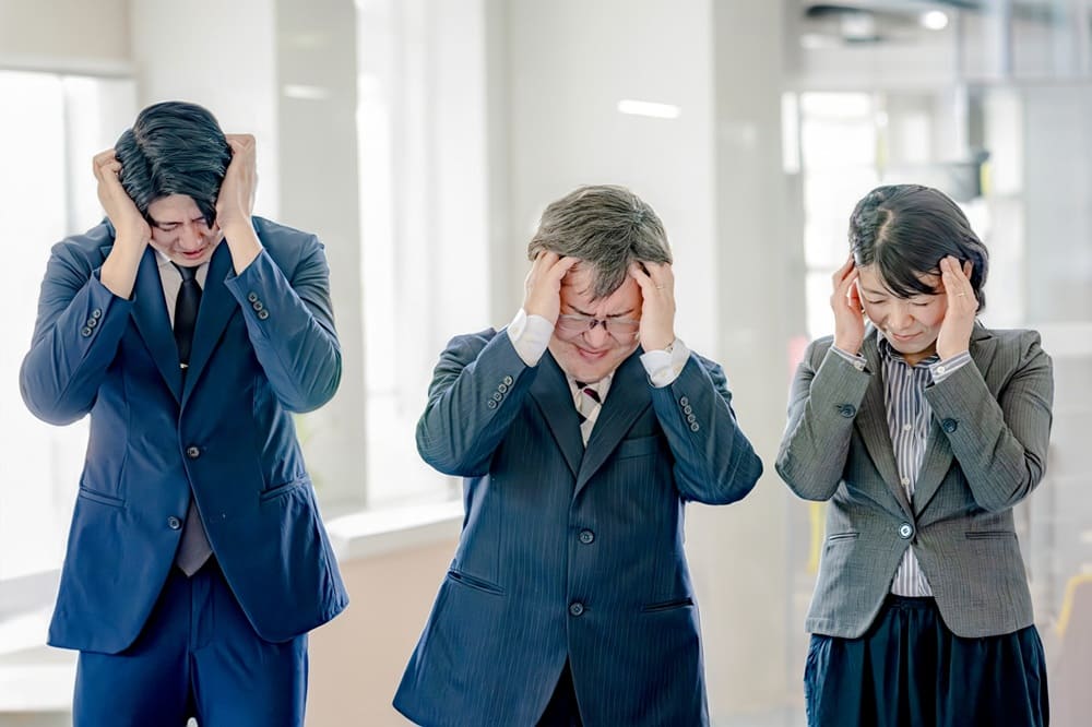 人材が見つからず頭を抱えているスーツを着た男女3人