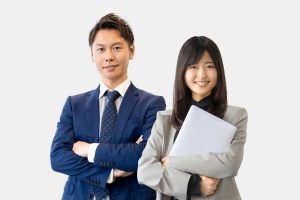 スーツを着て腕組みした笑顔のビジネスマン・ウーマン