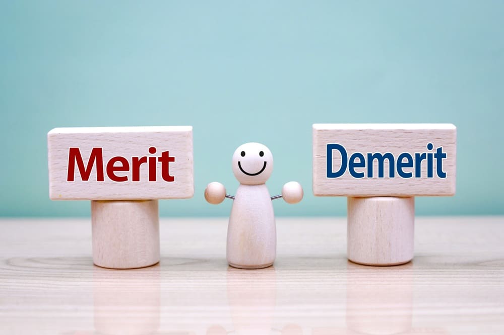 Merit、Demerittoとそれぞれ書かれた積み木とその間に置かれた人形