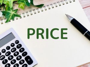 PRICEと緑の文字で書かれた画用紙と、それを囲むように置かれたペンと電卓