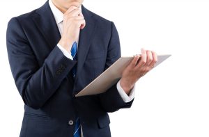 バインダーを片手に悩んでいる面接官