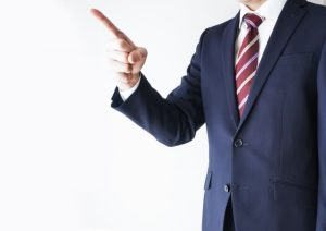指差しをするスーツを着た男性