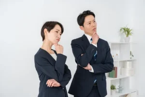 営業専任の不在や体制構築など、組織の課題について悩むスーツ姿の男女