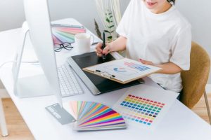 ペンタブレットとカラーパレットを使ってデザイン制作を行う女性