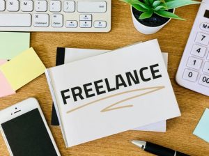 デスクの上に置かれた「FREELANCE」と書かれたノートやパソコン