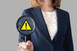 女性の採用担当者が虫眼鏡を持って志望者を評価しようとしている