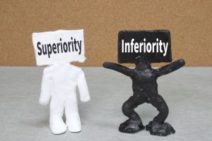 「superiority」「inferiority」と顔に書かれた2体の人形