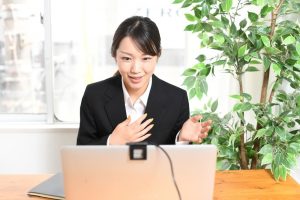 ノートPCの前でプレゼンをする若い女性