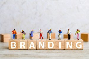 「BRANDING」と1文字ずつ書かれたブロックとそのブロックにそれぞれ乗っている人形