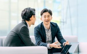 アドバイスするスーツの男性とそれを受ける男性