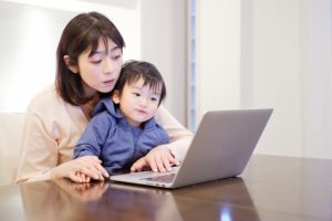 時短勤務での転職を検討し、育児と両立しながら自宅でパソコンに向かって働く主婦