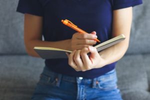 培ってきたスキルを活かし、ノートにメモをとって業務に取り組む女性の様子